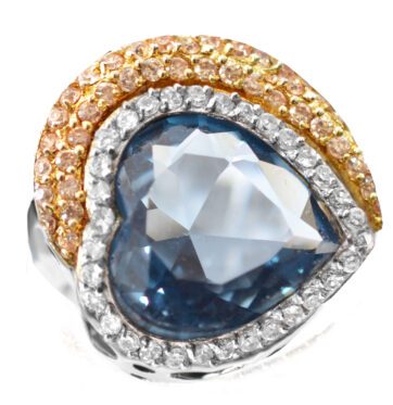Ασημένιο δαχτυλίδι με λευκές ζιργκόν πέτρες που πλαισιώνουν μεγάλη γαλάζια πέτρα σε σχήμα καρδιάς.