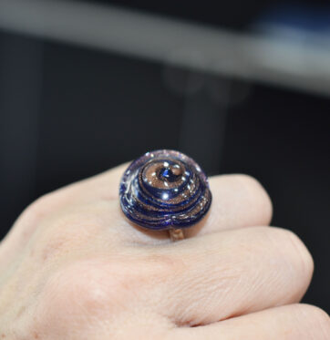 Ασημένιο δαχτυλίδι με μεγάλο μοτίφ από σμάλτο σε ιριδίζουσες αποχρώσεις μπλέ και καφέ.
