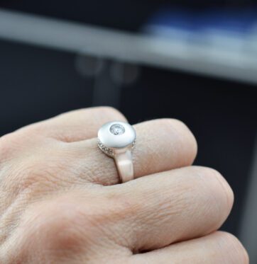 Ασημένιο δαχτυλίδι σε διπλή υφή λουστρέ και σαγρέ με λευκές πέτρες.