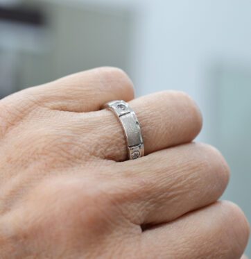 Ασημένιο δαχτυλίδι βέρα με λευκές πέτρες και σαγρέ υφή.