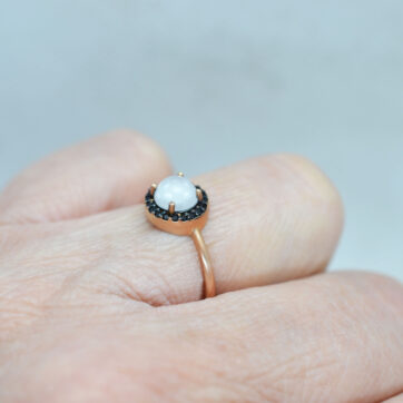 Ροζ χρυσό δαχτυλίδι με blue-black ζιργκόν πέτρες και κεντρική ανάγλυφη πέτρα στο χρώμα του πάγου.